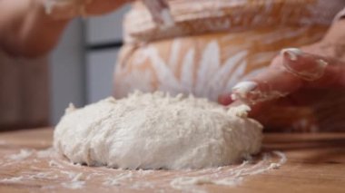 Kadın yapışkan hamuru ellerinden ayırıyor. Yakın plan..