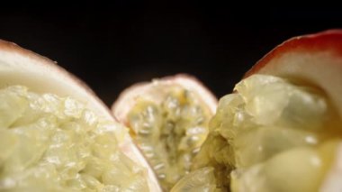 Kamera, dilimlenmiş tutku meyvelerinin iki yarısı arasında kayar. Makro çekim.