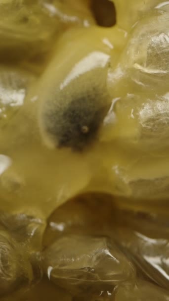 垂直录像 一半的激情水果 里面有种子和果汁 坠落的概念 黑色背景上的宏观滑块 — 图库视频影像