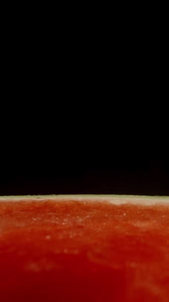 垂直录像 一种没有种子的西瓜的横截面 一半是红肉 背景是黑色的 多利滑翔机极端特写 — 图库视频影像