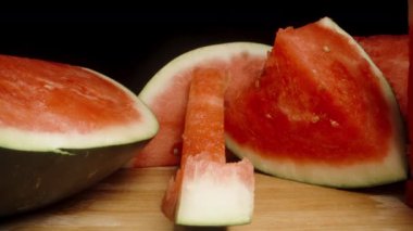 Çiğnenmiş karpuz kabuğu ahşap bir masada, sağlam parçalarla, doli şutla, yakın plan..