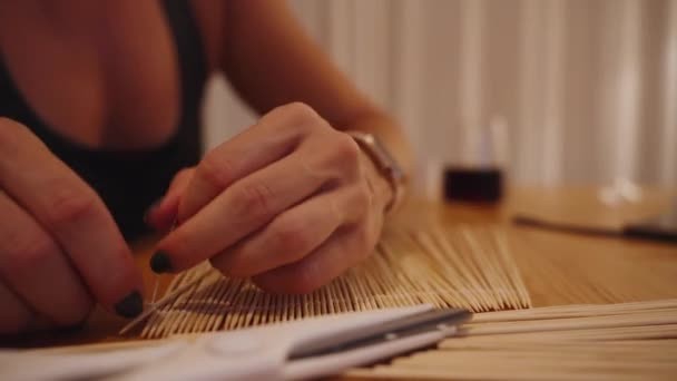 Eine Junge Frau Stellt Aus Essstäbchen Eine Holzmatte Zum Rollen — Stockvideo