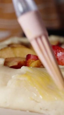 Dikey video. Silikon fırça kullanarak hamuru yumurta kabuğuyla kaplarlar..