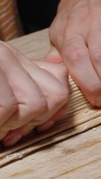 Вертикальное Видео Женщина Скручивает Суши Помощью Бамбукового Коврика Крепко Нажимает — стоковое видео