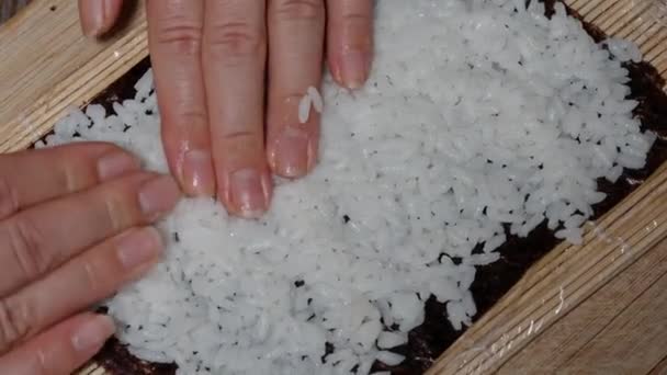 上から見ると 女性は海苔の上に米を均等に広げます — ストック動画