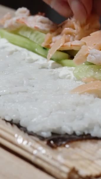 Függőleges Videó Lazacot Tesz Uborka Tetejére Sushi Tekercset Készít Rizs — Stock videók