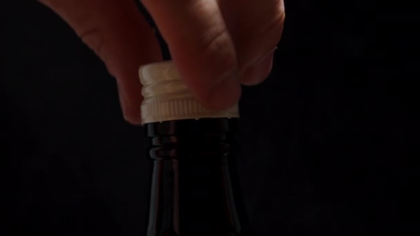 黒いアルコールボトルから白い帽子を解凍し クローズアップ — ストック動画