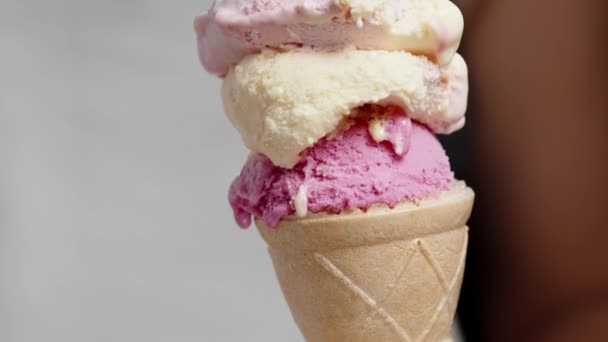 一个用粉色调的多色冰淇淋勺的华夫饼筒 一个女人用一个集装箱里的特殊勺子把它挖出来 特写镜头 — 图库视频影像