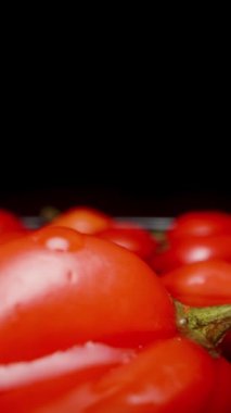 Dikey video. Kamera, Türkiye Yıldızı 'nın kırmızı kırmızı kırmızı kırmızı biberlerinin üzerinde yavaşça geri hareket ediyor..