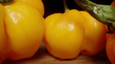 Tahta bir masada sarı Habanero biberleri. Dolly kaydırıcı aşırı yakın çekim.