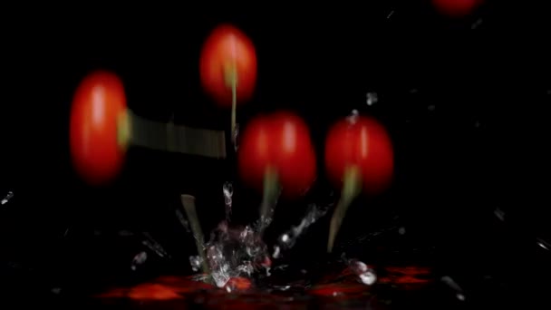 トルコの星の赤いミニペッパーは 遅い動きで 黒い背景に水が飛び散って水に落ちる — ストック動画