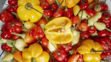 Kamera, Habanero ve chili 'nin de içinde bulunduğu renkli mini biberlerin bulunduğu bir tabağın üzerine yavaşça iner. Dolly kaydırıcı aşırı yakın çekim.