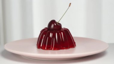 Ağır çekimde, kiraz çileği kırmızı jöleye düşer..