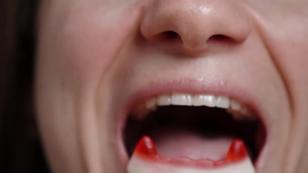 Eine Junge Frau Isst Gummibonbons Form Roter Vampirzähne Nahaufnahme — Stockvideo