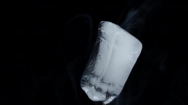 Ice Cube Rotates Black Background Emitting Smoke Close Shot Isolate — Stock Video