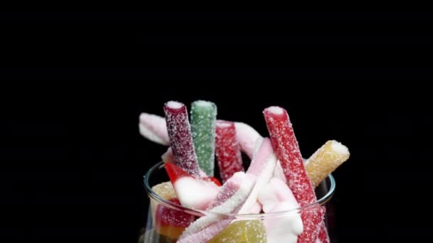 我把糖蜜糖放回杯子里 杯子里塞满了各种形状和颜色的糖蜜糖 上面撒满了糖 — 图库视频影像