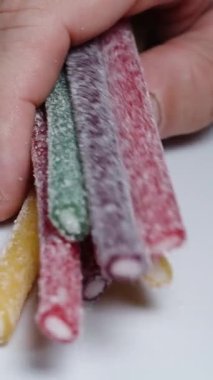 Farklı renklerdeki şeker kaplı jelibonlara dokunuyorum ve ellerim şekerle kaplanıyor..