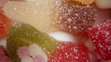 Farklı şekillerde ve tatlarda çeşitli renkli şekerlerin karışımı. Üst Manzara. Dolly kaydırıcı aşırı yakın çekim.