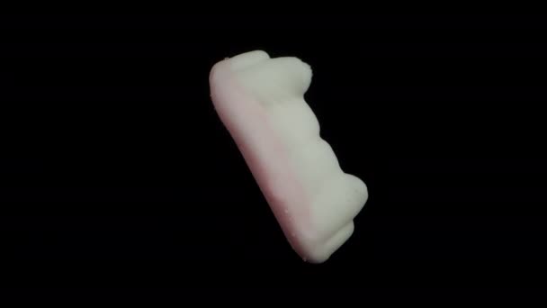 バンパイアの歯の形をしたガミーキャンディー ブラックバックに回転 — ストック動画