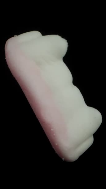 垂直录像 带有尖牙的吸血鬼牙齿形状的糖蜜糖果 在黑色的背景上旋转 被隔离 — 图库视频影像