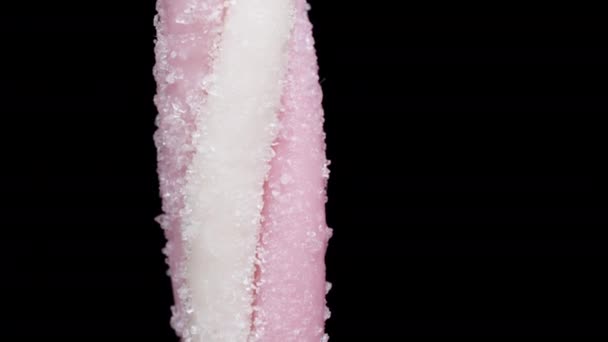 一个被糖衣包裹的螺旋形粉红咀嚼棒在黑色背景上旋转 隔离的 — 图库视频影像