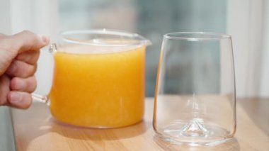 Portakal suyunu sürahide hamurla yavaşça bardağa döküyorum..