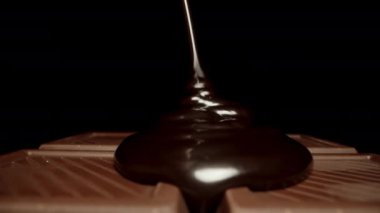 Alttan çikolataya sıvı siyah çikolata dökülüyor. Dolly kaydırıcı aşırı yakın çekim.