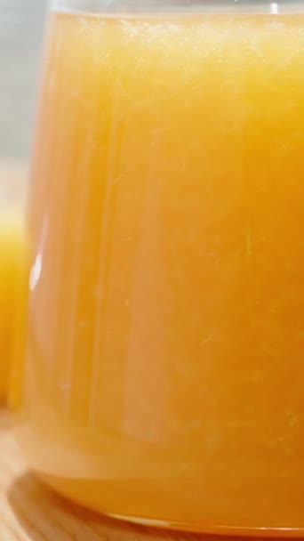 Vídeo Vertical Vaso Jugo Naranja Con Pulpa Sobre Telón Fondo — Vídeo de stock
