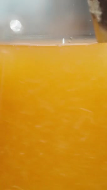 垂直录像 我在橙汁里搅拌纸浆的特写 动作缓慢 — 图库视频影像