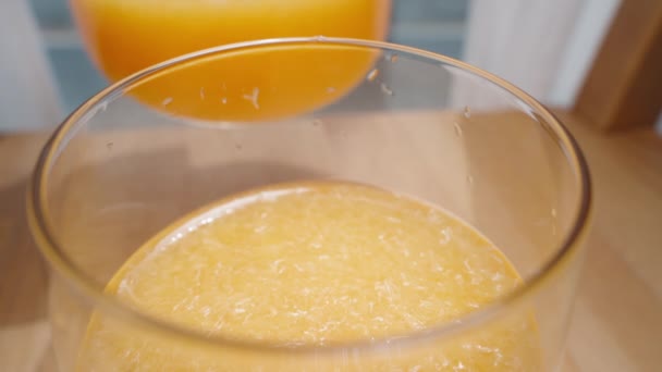 ガラスにパルプでゆっくりオレンジジュースを注いでいっぱいになるまで — ストック動画