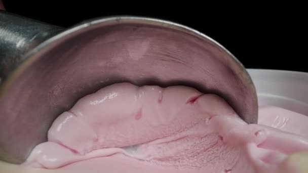 特別な金属製のスクープは ピンクのアイスクリームをカメラに向けて滑り アイスクリームのスクープをボールに転がします マクロ — ストック動画