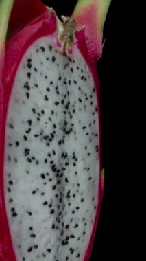 Dikey video. Makro zoom. Ejderha meyvesi dönüyor ve kamera beyaz ete zum yapıyor. Dolly kaydırıcı aşırı yakın çekim.