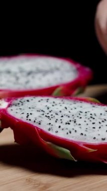 Dikey video. Ejderha meyvesindeki beyaz eti kaşıkla çıkarıp yerim..