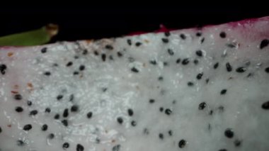 Ejderha meyvesi, Pitaya olarak da bilinir, beyaz teniyle, kamera yarımlardan birinin içinde hareket ederken. Dolly kaydırıcı aşırı yakın çekim.