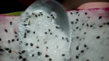 Kamera içine yerleştirildiği için Ejder meyvesinden beyaz eti çıkarmak için bir kaşık kullanıyor. Dolly kaydırıcı aşırı yakın çekim.
