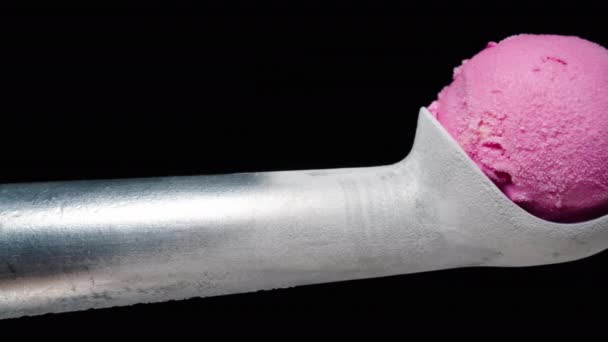 一个结霜的金属冰淇淋勺和一个粉红色的冰淇淋球放在里面 滑块射击 在黑色背景上被隔离 — 图库视频影像