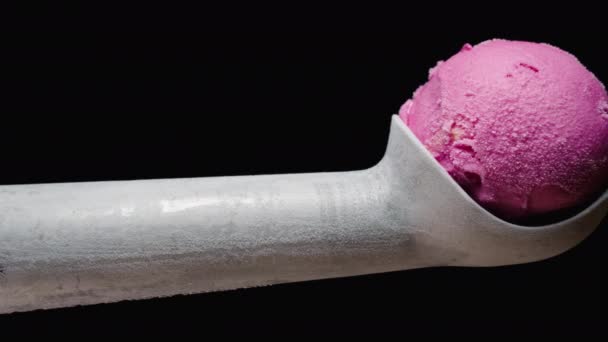 一个金属勺子 有一个粉色的雪糕球在黑色的背景上 被来自寒冷的霜冻覆盖 滑翔机 — 图库视频影像
