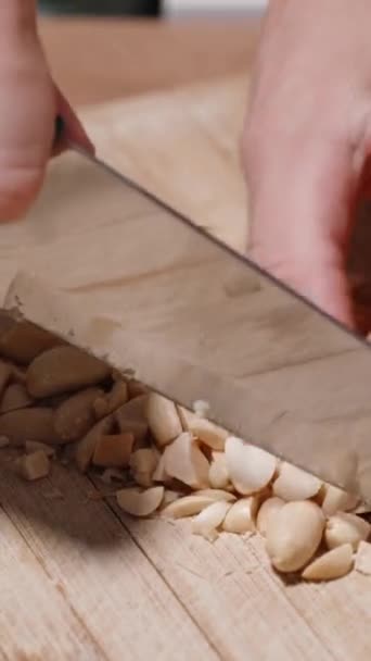 Vertical Video Woman Finely Chopping Peanuts Knife Wooden Cutting Board — Stock Video