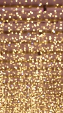 Dikey video. Yuvarlak Noel fenerleri kaotik bir şekilde titreşiyor, bir çoğu çevreyi aydınlatıyor..