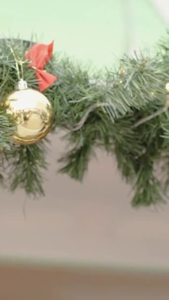 バーティカルビデオ 家の葉の枝に掛かっているクリスマスツリーの装飾 — ストック動画
