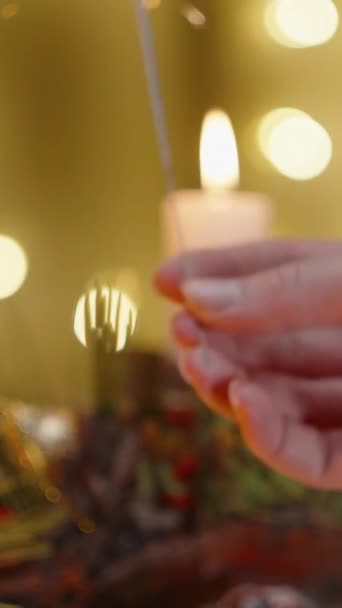 垂直录像 一只雌手从蜡烛上点燃了火花 照亮了圣诞装饰和家的内部 — 图库视频影像