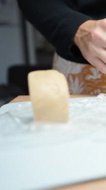 Dikey video. Kadın elinde zencefilli kurabiye için hamur yoğuruyor..