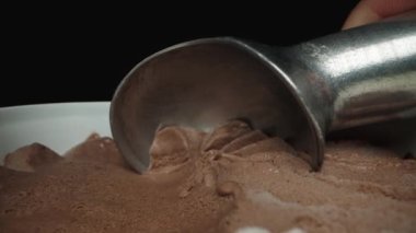 Dondurma kepçesi dondurmanın farklı renkleri üzerinde süzülür ve onu bir top haline getirir. Dolly kaydırıcı aşırı yakın çekim.