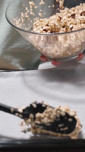 垂直录像 自制格拉诺拉的配料 谷物以及坚果和水果的混合物被铺在铺有羊皮纸的烤纸上 — 图库视频影像