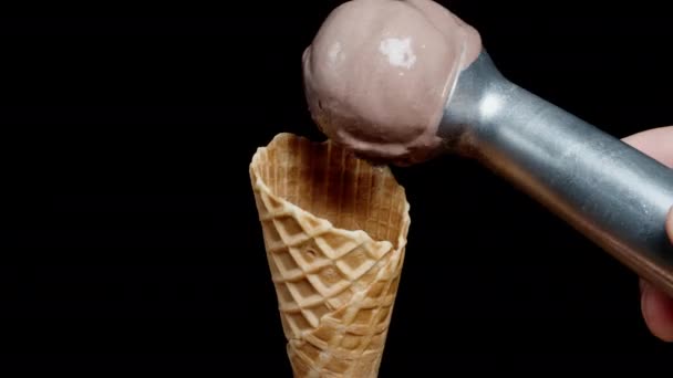 Используя Специальную Ложку Помещаю Шарик Шоколадного Мороженого Вафельный Конус Черном — стоковое видео