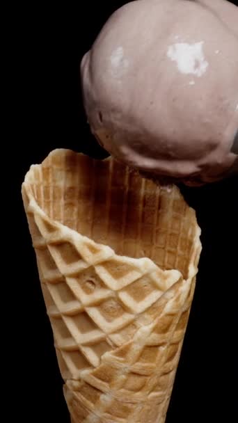 垂直录像 我用一个特殊的勺子 把一个巧克力冰淇淋球放在一个华夫饼筒里 放在一个黑色的背景上 — 图库视频影像