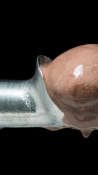 垂直录像 巧克力冰淇淋球在勺子上迅速融化 宏观变焦 黑色背景 时间间隔 — 图库视频影像