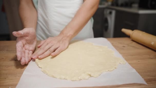 Kobieta Kształtuje Ciasto Okrągłą Formę Papierze Pieczenia Drewnianą Wałkownicą Leżącą — Wideo stockowe