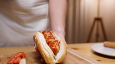 Kadın sosisliye mayonez döküyor, yavaş çekimde, yakın çekimde..