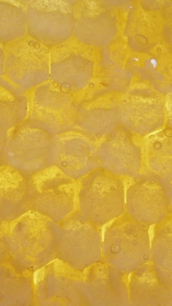 垂直录像 蜂蜜在金黄色的蜂窝上闪闪发光 宏观视图 — 图库视频影像